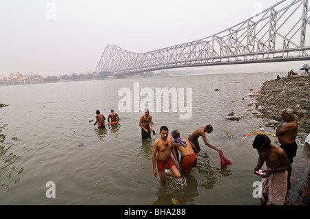 Pilger-Bad im Fluss Hooghly unterhalb der Howrah Brücke in Kalkutta. Stockfoto