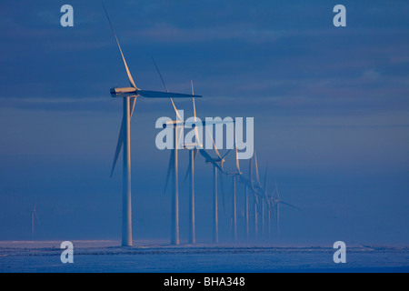 Windkraftanlagen im Nebel im Winter und Felder in Schnee bedeckt, Deutschland Stockfoto