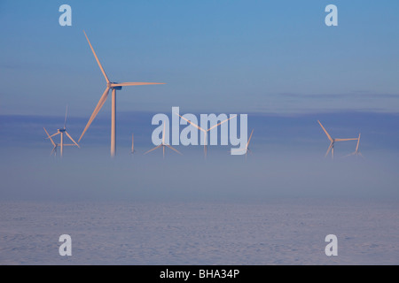 Windkraftanlagen im Nebel im Winter und Felder in Schnee bedeckt, Deutschland Stockfoto