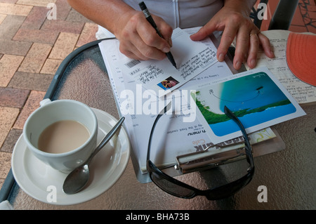 Frau schreiben Postkarten im Urlaub am Airlie Beach in Queensland Stockfoto