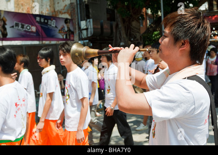 Ein Junge spielt auf einem Rohr während der Cheung Chau Bun Festival feierte im Jahr 2009 Stockfoto