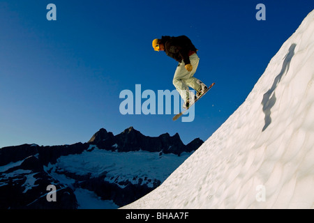 Snow Boarder macht einen Sprung auf Pisten im Bereich Juneau mit Mendenhall-Gletscher und Türme im Hintergrund, südöstlich, Alaska Stockfoto