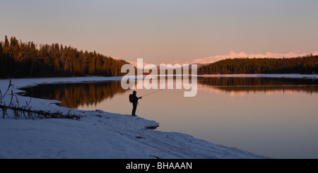 Einsamen Fischer angeln Kenai River im Winter bei Sonnenuntergang Stockfoto