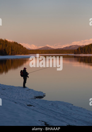 Einsamen Fischer angeln Kenai River im Winter bei Sonnenuntergang Stockfoto