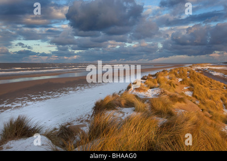 Schnee bedeckt die Dünen und Strand von Holkham Bay an der Küste von Norfolk im winter Stockfoto