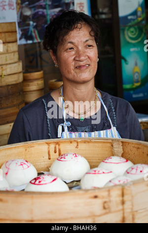 Eine Dame verkaufen traditionelle gedämpfte Brötchen während Cheung Chau Bun Festival feierte im Jahr 2009 Stockfoto