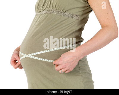 Schwangere Frau misst den Bauch mit einem Maßband Stockfoto