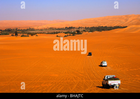 Mehrere Off-Road-Fahrzeuge nähert sich die Mandara-Oase im Meer Awbari Sand, Sahara-Wüste, Libyen Stockfoto