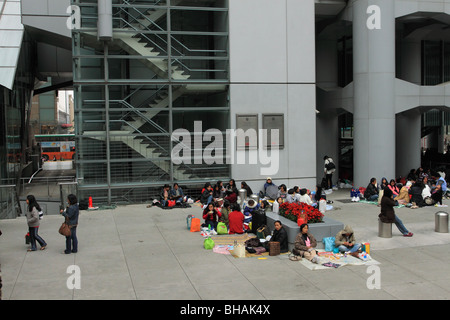 Philippinische Dienstmädchen zu sammeln, an einem Sonntag unter der HSBC Gebäude in Hong Kong Stockfoto