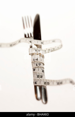 Messer und Gabel gewickelt in Maßband Stockfoto