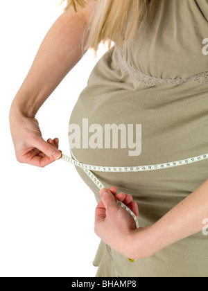 Schwangere Frau misst den Bauch mit einem Maßband Stockfoto