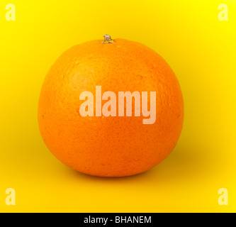 Eine Orange Mandarine auf einem gelben Hintergrund. Stockfoto