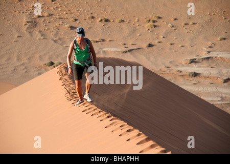 Wandern entlang der unberührten Grat einer riesigen roten Sanddüne in der Wüste von Namibia Stockfoto