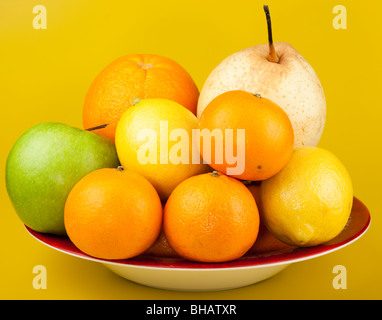 Obst auf einem gelben Hintergrund mit einem Farbverlauf fotografiert. Stockfoto