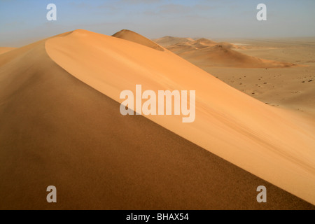 Wandern entlang der unberührten Grat einer riesigen roten Sanddüne in der Wüste von Namibia Stockfoto