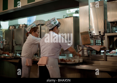 Kellnerinnen im Cafe Du Monde serviert Krapfen und Chicorée Kaffee am Morgen. Stockfoto