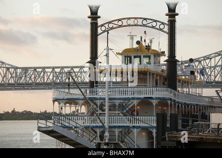Creole Queen angedockt in den frühen Morgenstunden auf dem Mississippi mit Crescent City Connection Bridge im Hintergrund. Stockfoto