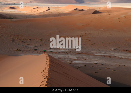 Wandern entlang der unberührten Grat einer riesigen roten Sanddüne in der Wüste von Namibia Stockfoto