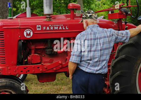 Man prüft einen restaurierte Farmall Traktor. Traktor und LKW zeigen 2008 Cookville TN Stockfoto