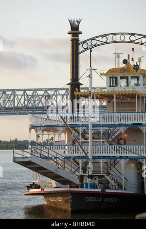 Creole Queen angedockt am Mississippi River in den frühen Morgenstunden mit Crescent City Connection Bridge im Hintergrund. Stockfoto