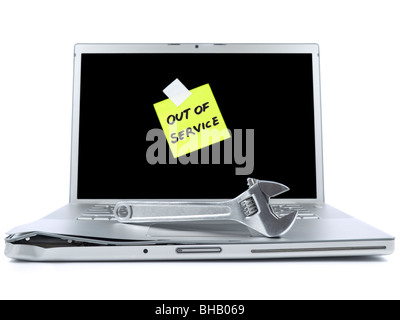 Beschädigten Laptop mit einem Post-It aus Service und einem Schraubenschlüssel über es sagen. Isoliert auf weiss. Stockfoto