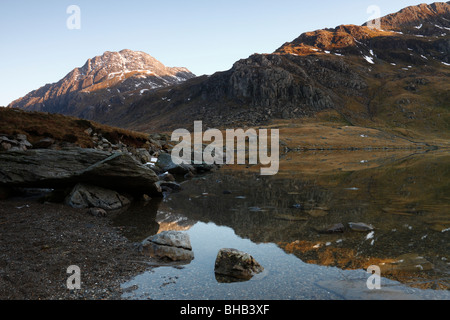 Die Westwand des Tryfan, ein Berg in Snowdonia, Wales, im Abendlicht getaucht und spiegelt sich in den Gewässern des Llyn Idwal Stockfoto