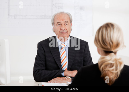 Senior-Unternehmer im Gespräch mit einer Frau Stockfoto