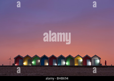 Bunte, beleuchtete Strandhütten bei Sonnenuntergang am Strand von Blyth, Northumberland, Vereinigtes Königreich Stockfoto