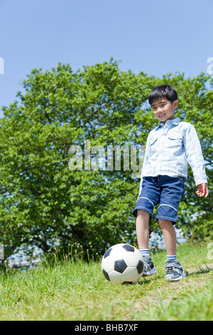 Japan, Tokyo Präfektur, jungen Fußball spielen, niedrigen Winkel Ansicht Stockfoto