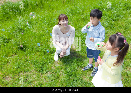 Japan, Tokyo Präfektur, Kinder Seifenblasen, Mutter beobachten Stockfoto