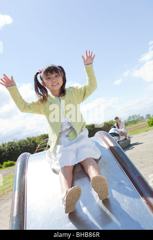 Japan, Tokyo Präfektur, Mädchen spielen auf Folie, Lächeln, Porträt Stockfoto