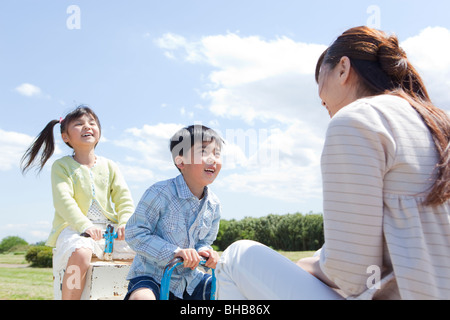 Japan, Tokyo Präfektur, Mutter und Kinder spielen auf Wippe Stockfoto