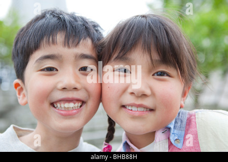 Japan, Tokyo Präfektur, jungen und Mädchen Lächeln auf den Lippen, Wange an Wange, Nahaufnahme Stockfoto