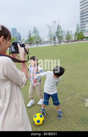 Japan, Tokyo Präfektur, Mutter Fotografieren Kinder im park Stockfoto