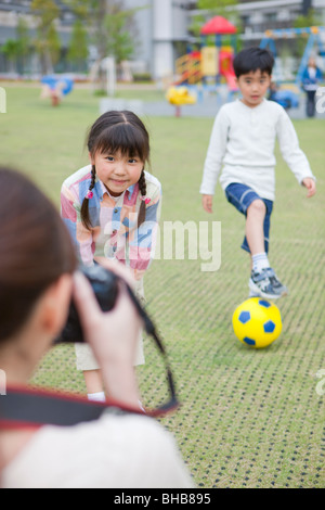 Japan, Tokyo Präfektur, Mutter Fotografieren Kinder im park Stockfoto