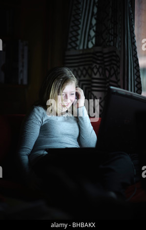 Ein Teenager-Mädchen telefonieren mit einem Handy und mit einem Laptop-Computer zu Hause, UK Überprüfung ihrer social Networking-Website und e-Mail Stockfoto