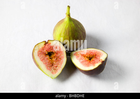 Ganze und halbierte Feigen auf weißem Hintergrund Stockfoto