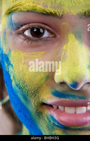 Weibliches Gesicht bedeckt in Holi Farben Stockfoto