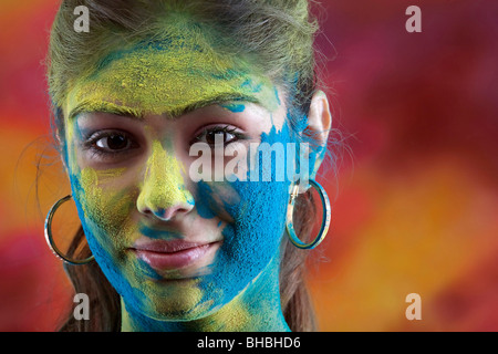 Weibliches Gesicht bedeckt in Holi Farben Stockfoto