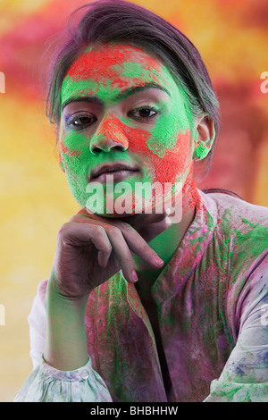 Weibliches Gesicht bedeckt in Holi Farben Stockfoto