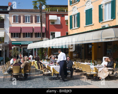 Sirmione, Lombardei, Italien. Kellner servieren Kunden auf ein Straßencafé mit Blick auf den Gardasee. Stockfoto