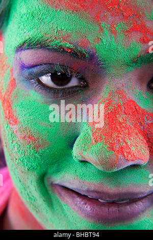 Weibliches Gesicht bedeckt in Holi Farben Stockfoto