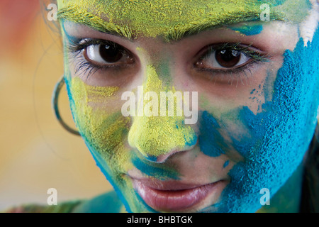 Weibliches Gesicht bedeckt in Holi Farben Stockfoto