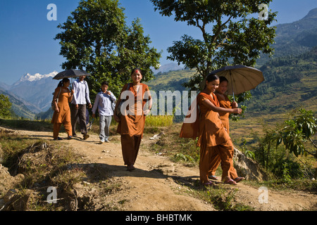 Schulmädchen in orange Uniformen Fuß zur Schule entlang ein Trail - um MANASLU Trekking, NEPAL Stockfoto