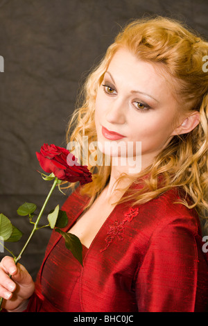 Porträt der schönen jungen Frau mit roten Rose in der Hand. Stockfoto