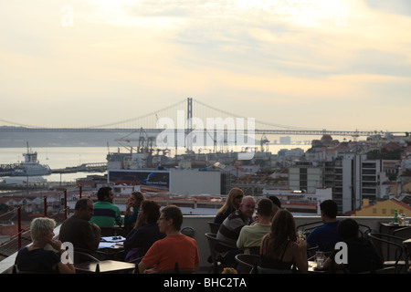 Menschen, die in einer Open-Air-Terrasse-Restaurant mit Blick auf die Tage-Fluss und die Brücke 25 April trinken Stockfoto