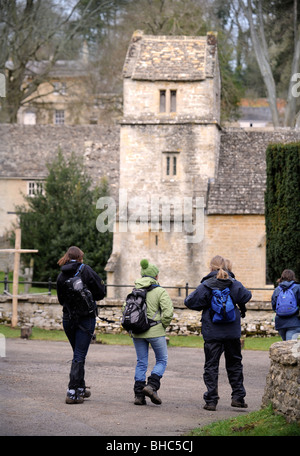 Eine Gruppe von Wanderern pass St.-Margarethen Kirche, Bagendon Gloucestershire UK Stockfoto