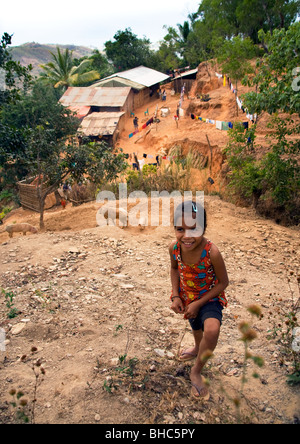 Junges Mädchen am Hang über dem abgelegenen Bergdorf der Hütten wo arme Bauern, die Aufzucht von Schweinen in Ost-Timor Stockfoto