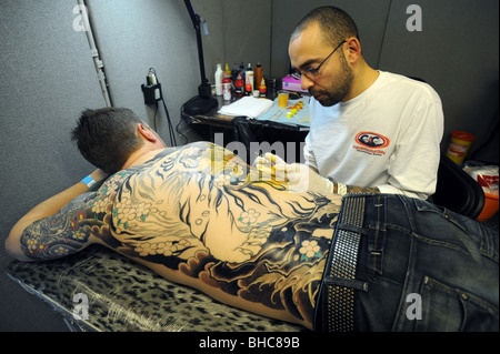 Ein Tätowierer bei der Arbeit während der Brighton Tattoo Convention 2010 in Brighton racecourse Stockfoto