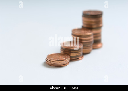 4 Stapel von Münzen erschossen auf einem weißen Hintergrund. Jeder Stapel zunimmt an Größe. Stockfoto